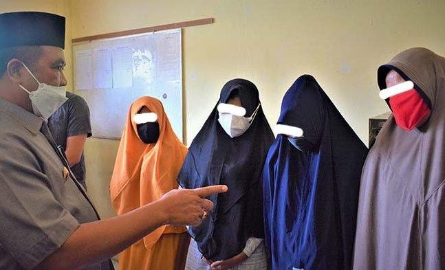 Bupati Aceh Barat, Ramli MS bersama Satpol PP dan WH saat memperlihatkan mucikari dan empat orang wanita yang ditangkap di salah satu tempat penginapan di Jalan Gajah Mada Meulaboh, dalam kasus prostitusi, Senin (13/9/2021), yang berlangsung di Kantor Satpol PP dan WH. 