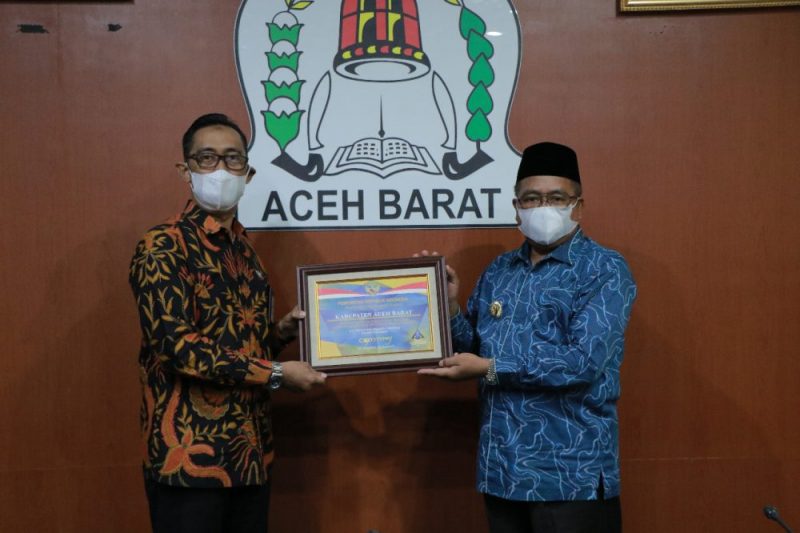 Kepala Kantor Wilayah Direktorat Jendral Pembendaharaan (DJPb) Aceh, Syafriadi, SE., M.EC., PH.d menyerahkan plakat dan piagam kepada Bupati Aceh Barat H. Ramli MS diruang kerja Bupati setempat