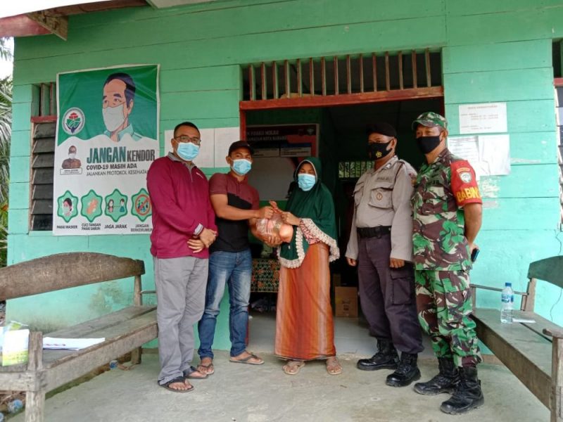 Warga menerima bantuan dari aparatur desa setelah vaksinasi