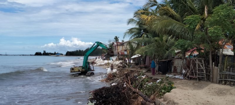 Warga dibantu Beko yang disediakan oleh Zulkarnain memasang Geobag di sepanjang pantai Palak Kerambil
