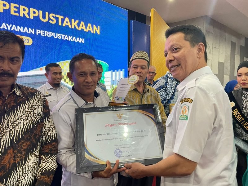 Kepala Disperpusip Kabupaten Aceh Besar, Fazlun SH MT, menerima penghargaan terbaik 2 atas capaian implementasi program transformasi perpustakaan berbasis inklusi sosial tahun 2023, dari Pj Gubernur Aceh, di Gedung Perpustakaan Wilayah Aceh, Banda Aceh, Rabu (22/11/2023).