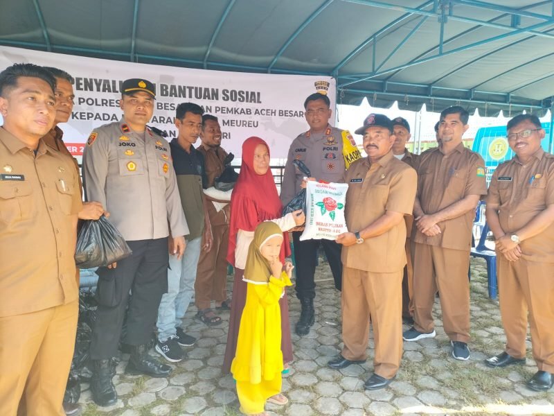 Pj Bupati Aceh Besar Muhammad Iswanto SSTP MM, yang diwakili Asisten II Sekdakab Aceh Besar M. Ali S.Sos MSi disaksikan Kapolres Aceh Besar AKBP Carlie Syahputra Bustamam S.I.K MH menyerahkan bantuan secara simbolis kepada warga Meureu, Indrapuri, Senin (4/12/2023). 