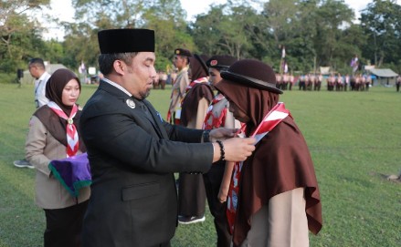 Pj Bupati Aceh Besar Muhammad Iswanto SSTP MM, menyematkan tanda peserta Perkemahan Bersama Penggalang dan Penegak Kwartir Cabang Pramuka Aceh Besar Tahun 2024, di Bumi Perkemahan Pramuka Kota Jantho, Aceh Besar, Jum'at (23/2/2024) sore. FOTO/ PROKOPIM PEMKAB ACEH BESAR