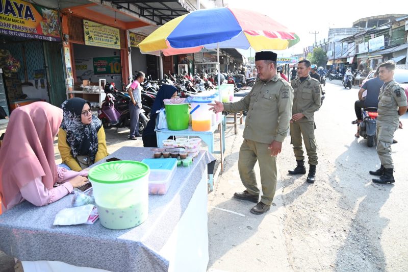 Personel Satpol PP dan WH Aceh Besar, memantau suasana pedagan musiman penjual panganan berbuka puasa di kawasan Lambaro, Kecamatan Ingin Jaya, Aceh Besar, Jumat (15/03/2024) sore.