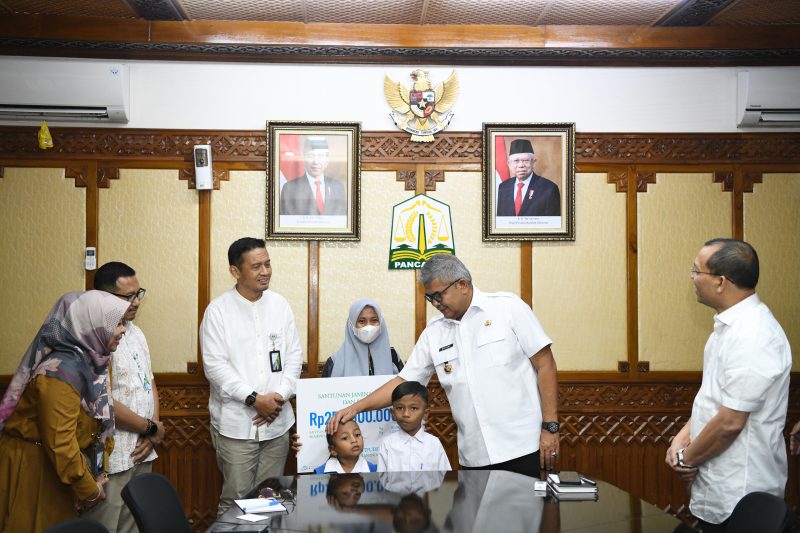 Pj Gubernur Aceh Bustami, SE, M.Si  didampingi Direktur Keuangan BPJS Ketenagakerjaan, menyerahkan Santunan Jaminan Kematian dan Beasiswa kepada kepada Istri dan Anak Almarhum Yusri Afifuddin di Ruang Rapat Gubernur Aceh, Jumat (22/03/2024). 