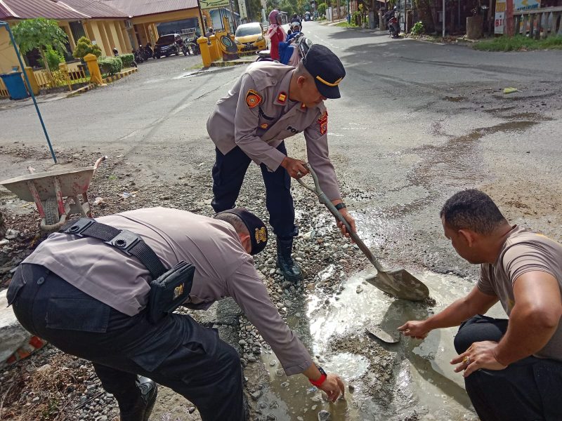 Bersama personel Kapolsek Blangpidie Iptu Jarot Hasmoro tambal jalan berlubang