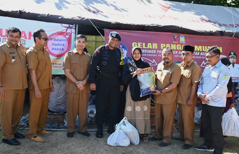 Asisten II Sekdakab Aceh Besar, M Ali, S.Sos, M.Si menyerahkan secara simbolis belanja sembako murah kepada masyarakat pada Bazar Pangan Murah yang digelar Pemkab Aceh Besar bekerjasana Satbrimob Polda Aceh dan Perum Bulog Kanwil Aceh, di Halaman Masjid Ladong, Kecamatan Mesjid Raya, Aceh Besar, Selasa (02/04/2024).