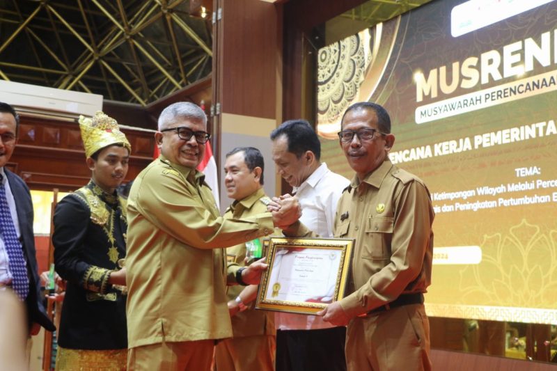 Pj Gubernur Aceh Bustami Hamzah ( kanan) memberikan penghargaan kepada Pj Bupati Pidie Jaya Ir Jailani Beuramat ( Kiri) sebagai katagori terbaik 1 pada Anugerah Prof. A . Majid Ibrahim ke-X. Banda Aceh , 22/4/2024