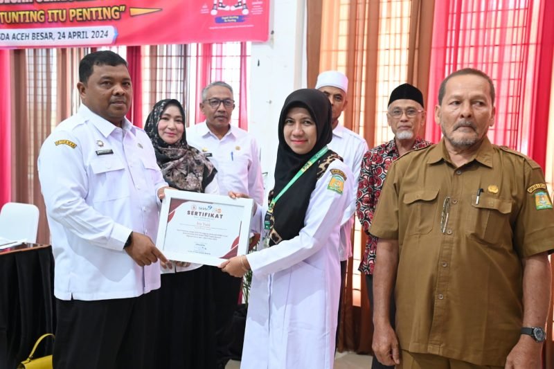 Sekdakab Aceh Besar, Drs Sulaimi MSi menyerahkan piagam penghargaan kepada tiga peraih penghargaan terbaik pada acara Diseminasi Hasil Audit Kasus Stunting Kabupaten Aceh Besar Semester 1 Tahun 2024, di Aula Dekranasda, Gampong Gani, Kecamatan Ingin Jaya, Aceh Besar, Rabu (24/4/2024).