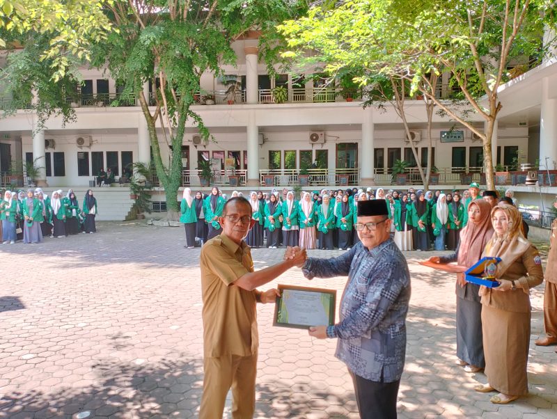 Pj Sekda Pidie Jaya Bahron Bakti, ST. MT (kanan) menerima piagam penghargaan dari ketua yayasan PTI Al Hilal Sigli Abdullah Ali, M.Pd, Senin (6/5/2024). (Foto | Muhammad Rissan/NOA.co.id) 