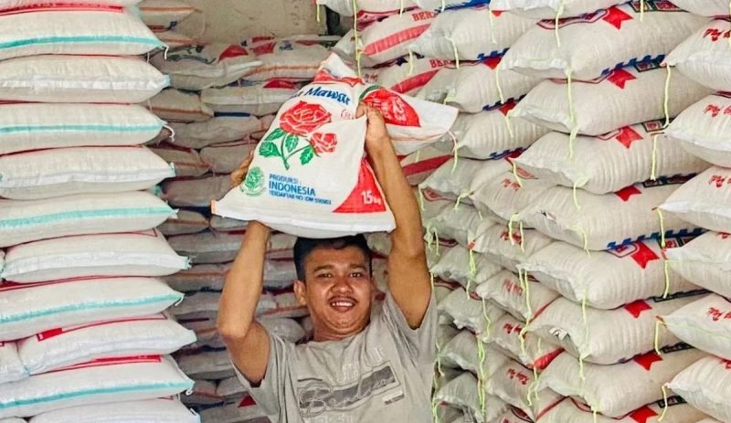 Pekerja mengangkat satu karung beras pesanan konsumen di sebuah toko penjualan bahan pokok di ruas Jalan Sisingamangaraja, Meulaboh, Kabupaten Aceh Barat, Kamis (31/8/2023). (Foto: noa.co.id/FA)
