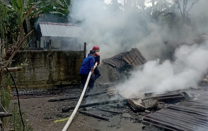 Petugas pemadam kebakaran sedang melakukan pendinginan di rumah terbakar (Foto: noa.co.id)