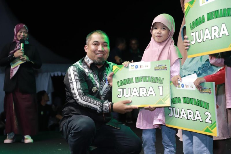 Pj Bupati Aceh Besar, Muhammad Iswanto, S.STP MM menyerahkan hadiah kepada juara lomba mewarnai pada penutupan Bazar UMKM Expo Aceh Besar dalam rangkaian memperingati HUT ke-40 Kota Janto di Jantho Sport City (JSC), Kota Jantho, Aceh Besar, Sabtu (01/06/2024) malam. Foto/NOA.co.id
