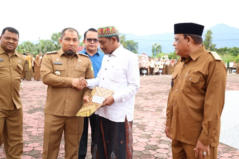 Pj Bupati Aceh Besar Muhammad Iswanto SSTP MM menyerahkan Surat Keputusan Pengakuan dan Perlindungan Masyarakat Hukum Adat kepada perwakilan imuem mukim di halaman Kantor Bupati Aceh Besar, Kota Jantho, Senin (3/6/2024). Foto: Hidayat S/NOA.co.id