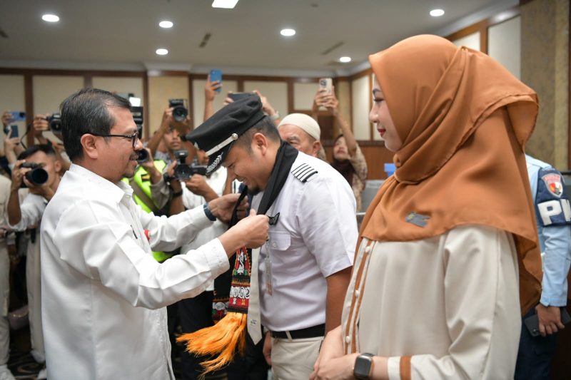 Pj. Sekda Aceh, Azwardi AP mengalungkan Sal kepada Kapten Pesawat Super Jet Air Fanzal Asri Zulkarnain, yang baru saja mendaratkan pesawat jenis Airbus 320-200, yang melayani rute penerbangan Jakarta- Aceh, Banda SIM, Blang Bintang, Jumat (14/06/2024). Foto: dok. Biro Adpim Setda Aceh.