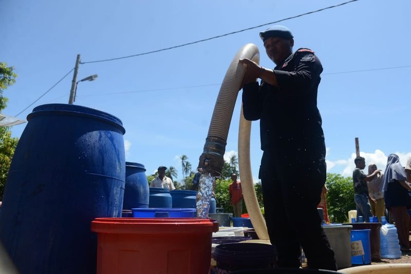 Personel Brimob Polda Aceh memasukkan air bersih dari mobil tangki ke sejumlah ember penampungan di Gampong Lamcok, Kecamatan Lhoknga, Kabupaten Aceh Besar, Aceh, Sabtu (15/6/2024). Pemerintah daerah setempat mengerahkan lima unit mobil tangki dan satu unit mobil water cannon dari Brimob Polda Aceh untuk memasok air bersih bagi kebutuhan warga di 17 desa di wilayah kecamatan Lhoknga, kabupaten Aceh Besar yang terdampak kekeringan akibat kemarau. NOA.co.id/Farid Ismullah