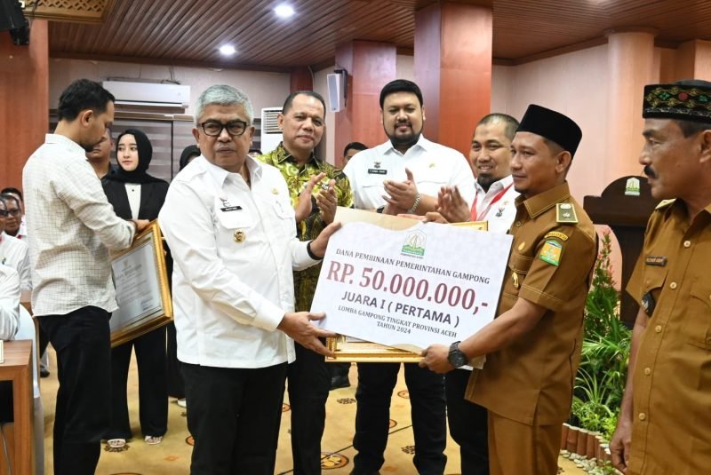 Keuchik Bueng Sidom, Muhammad Yanis, menerima penghargaan dari Penjabat Gubernur Aceh, Bustami Hamzah. Foto: Aprizali Munandar/Noa.co.id