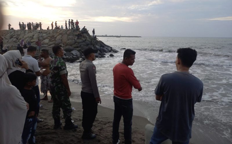 Sejumlah warga menyaksikan proses pencarian dua korban yang menghilang usai tenggelam di Pantai Tanoh Aneo Aceh Utara. Foto: Dok. Polsek Muara Batu/NOA.co.id