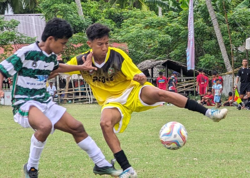 Pemain sepak bola Popda Pidie saat berebut bola dengan pemain Popda Aceh Singkil pada laga perdana Popda Aceh ke XVII di lapangan Matang Rayuek, Kecamatan Peudawa Kabupaten Aceh Timur, Jumat, (5/7/2024). Foto: Amir Sagita/NOA.co.id