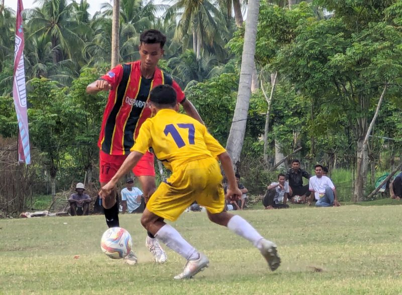 Pemain sepak bola Popda Pidie saat menggiring bola dan dikawal ketat pemain Aceh Tamiang pada laga lanjutan Pool C di lapangan Matang Raya, Kecamatan Peudawa, Kabupaten Aceh Timur, Selasa, (9/7/2024) (Foto Amir Sagita-noa.co.id)