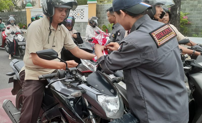 Himpunan Mahasiswa Pelajar Aceh Singkil (HIMAPAS) berbagi bendera merah putih kepada pengendara di lokasi simpang Lampriet Banda Aceh, Sabtu (10/8/2024). (Foto : Farid Ismullah/NOA.co.id).