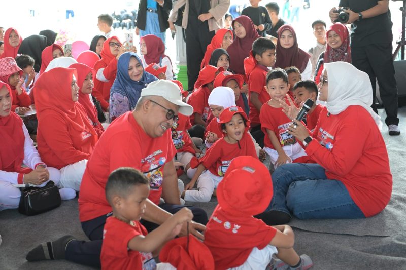Pj Gubernur Aceh Bustami bersama istri Mellani Subarni bermain, bercerita, dan membagikan hadiah untuk anak-anak dalam momentum peringatan Hari Anak Nasional yang digelar Pemerintah Aceh di Lapangan Blang Padang, Minggu, (11/8/2024). Foto: Humas Pemprov Aceh