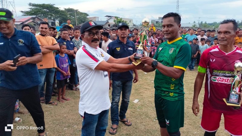 Camat Muara Tiga, Kabupaten Pidie, Provinsi Aceh, Bakhtiar, SKM, M.Kes saat menyerahkan Tropy Juara pertama sepak bola usia-40 dalam rangka HUT Kemerdekaan RI ke 79 Kecamatan Muara Tiga, di lapangan Suka Jaya, Sabtu, (31/8/2024) (Foto Amir Sagita.NOA.co.id).