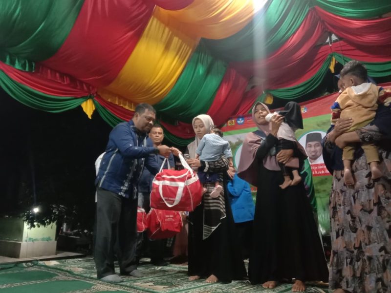 Sekda Aceh Besar Drs Sulaimi MSi menyerahkan bingkisan kepada masyarakat usai membuka pelaksanaan PKM Internasional, di Gampong Ie Seum, Kecamatan Mesjid Raya, Kabupaten Aceh Besar, Selasa (3/9/2024) malam. Foto: Prokopim Pemkab Aceh Besar