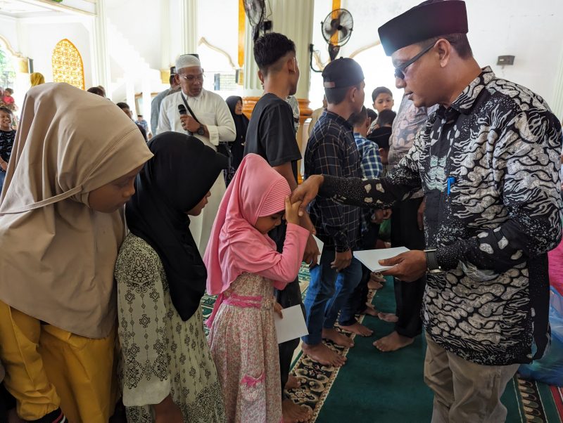 Sekcam Muara Tiga, Supriadi,SP saat menyerahkan santunan kepada anak yatim di mesjid kecamatan, Senin (16/9/2024) (Foto Amir Sagita.NOA.co.id).