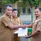 PJ Bupati Pidie Drs Samsul Azhar saat menyerahkan SK kenaikan pangkat kepada Kabag Pemerintahan setempat Almanda di lapangan tengah kantor Bupati setempat, Senin (7/10/2024). Foto: dok. Amir Sagita/NOA.co.id