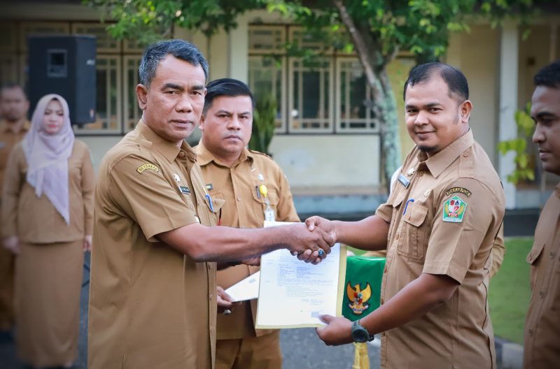 PJ Bupati Pidie Drs Samsul Azhar saat menyerahkan SK kenaikan pangkat kepada Kabag Pemerintahan setempat Almanda di lapangan tengah kantor Bupati setempat, Senin (7/10/2024). Foto: dok. Amir Sagita/NOA.co.id