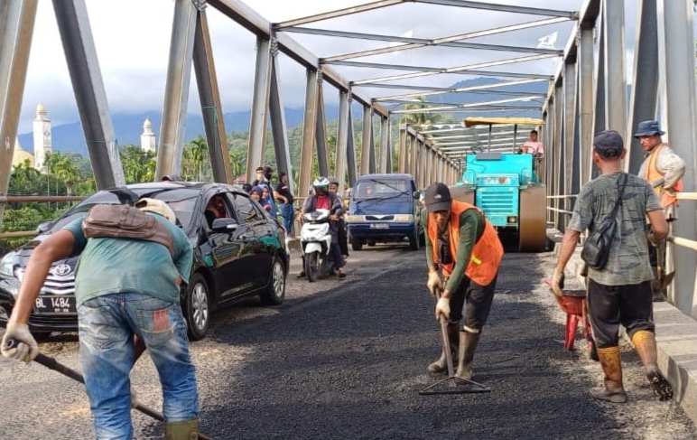 Relawan pasangan calon bupati dan wakil bupati Aceh Barat Daya, Salman Alfarisi dan Yusran menambal lantai jembatan Guhang-Blangpidie. (Foto. Teukunizar/NOA.co.id)
