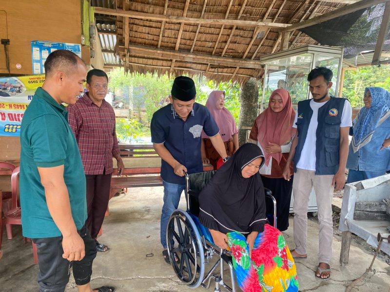 Anggota DPRA Khalid,S.Pd.I, saat menyerahkan kursi roda kepada warga Gampong Jok Tanjong, Kecamatan Padang Tiji, Jumat (6/12/2024) (Foto.Amir Sagita.NOA.co.id).