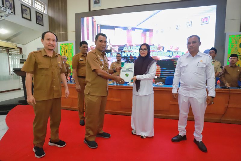 Pj Bupati Pidie, Drs Samsul Azhar, menyerahkan dokumen BLUD kepada Kepala Puskesmas secara simbolis, Senin (30/12/2024) (Foto.Amir Sagita.NOA.co.id).