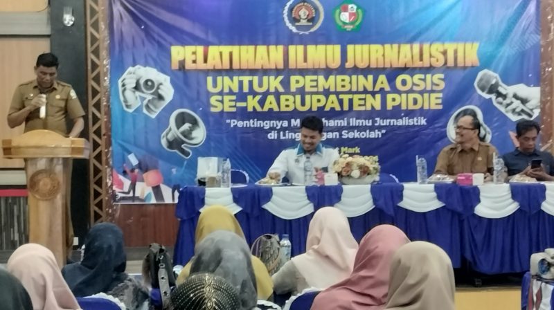 Pj Sekdakab Pidie, Jufrijal saat membuka pelatihan jurnalistik untuk guru pendamping OSIS se-Kabupaten Pidie, di Aula Suman Mart, Kota Sigli, Selasa (24/12/2024) (Foto.Amir Sagita. NOA.co.id).