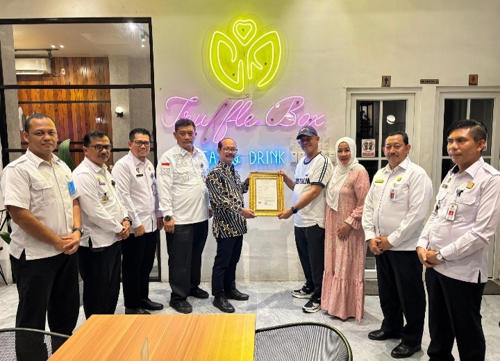 Kepala Kantor Wilayah Kementerian Hukum Aceh, Meurah Budiman saat menyerahkan sertifikat merek kepada pelaku usaha Kafe Truffle Box, Langsa, Rabu (15/1/2025). (Foto : Humas Kanwil Kemenkum Aceh).