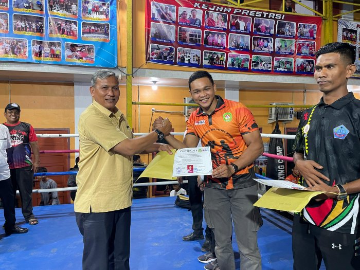 Kadisparpora Aceh Besar/Ketua Pertina Aceh Besar Abdullah SSos MSi, menyerahkan sertifikat kepada seorang pelatih tinju pada pembukaan turnamen DJBC Boxing Cup I Se-Aceh, di Sasana Tinju DJBC, Gampong Bayu, Kecamatan Darul Imarah, Aceh Besar. Foto: Dok. MC Aceh Besar