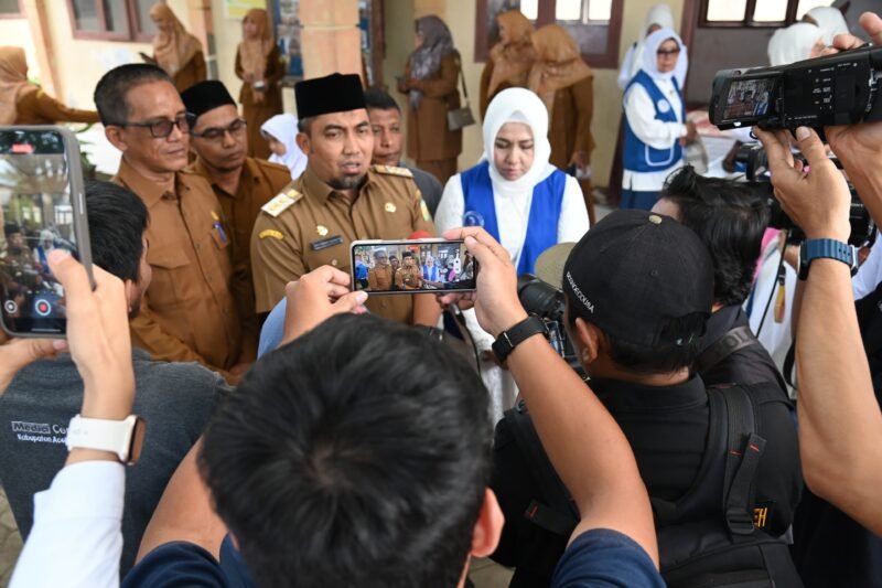 Pj Bupati Aceh Besar Muhammad Iswanto, S.STP, MM memberi keterangan pers kepada media elektronik seusai acara pembagian Makanan Bergizi Gratis (MBG) di SDN Mon Singet, Gampong Kajhu, Kecamatan Baitussalam, Aceh Besar, Senin (10/02/2025). Foto: Dok. MC Aceh Besar