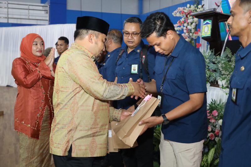 Pj Bupati Aceh Besar Muhammad Iswanto SSTP MM, di dampingi Pj Ketua TP PKK Aceh Besar Cut Rezky Handayani SIP MM, menyerahkan cinderamata kepada pegawai Prokopim Pemkab Aceh Besar pada silaturrahmi Pemkab Aceh Besar, di Gedung JSC, Kota Jantho, Aceh Besar, Senin (10/2/2025) malam. Foto: Dok. Prokopim Pemkab Aceh Besar