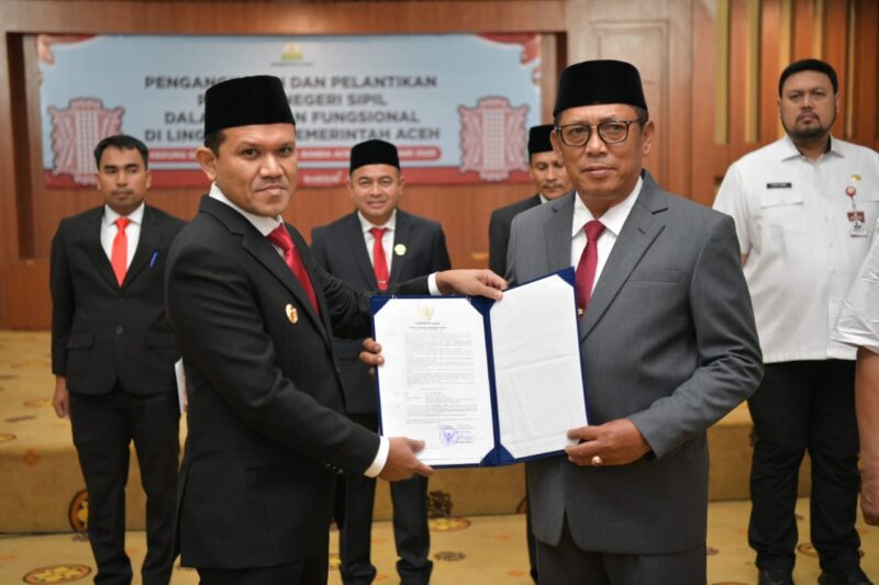 Wakil Gubernur Aceh, Fadhlullah, menyerahkan surat keputusan (SK) penunjukan Alhudri sebagai Pelaksana Tugas (Plt) Sekretaris Daerah Aceh menggantikan Muhammad Diwarsyah, di Gedung Serbaguna Kantor Gubernur Aceh, pada Rabu, (19/2/2025). Foto: Dok. Prokopim Setda Aceh