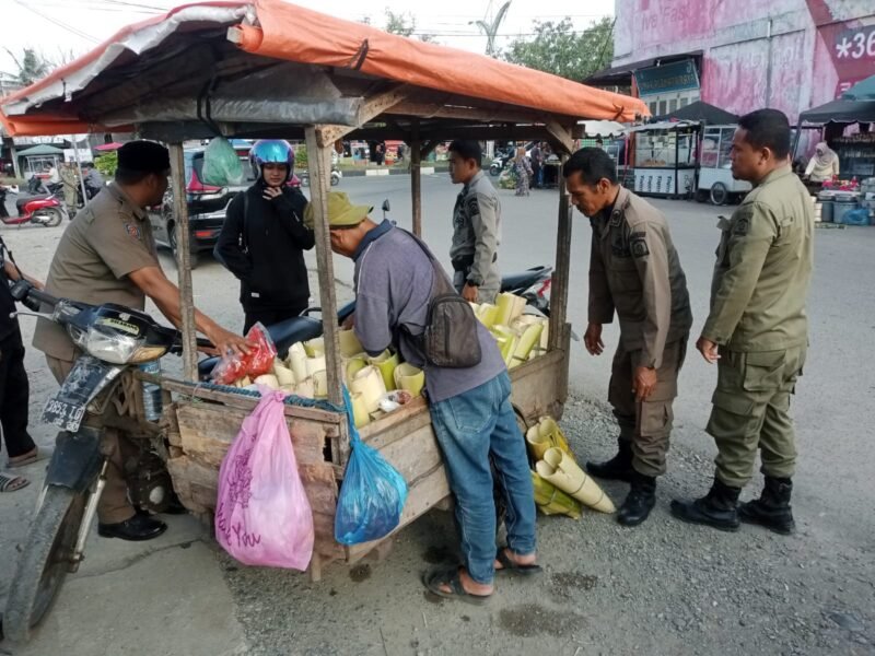 Personel Satpol PP dan WH Aceh Besar, menata pedagang musiman penjual panganan berbuka puasa di kawasan Lambaro, Kecamatan Ingin Jaya, Aceh Besar, Senin(03/03/2025) sore. Foto: Dok. MC Aceh Besar