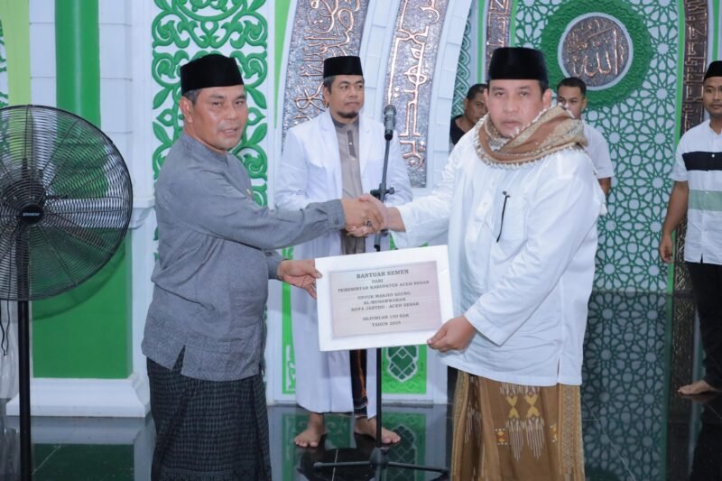 Bupati Aceh Besar, H. Muharram Idris (Syech Muharram), menyerahkan 150 sak semen secara simbolis kepada Imuem Chiek Masjid Agung Al-Munawwarah Tgk Junaidi (Abah Junaidi) dalam Safari Ramadhan perdana tahun 1446 H di Masjid Agung Al-Munawwarah, Kota Jantho, Aceh Besar, Senin (5/3/2025). Foto: Dok. Prokopim Pemkab Aceh Besar