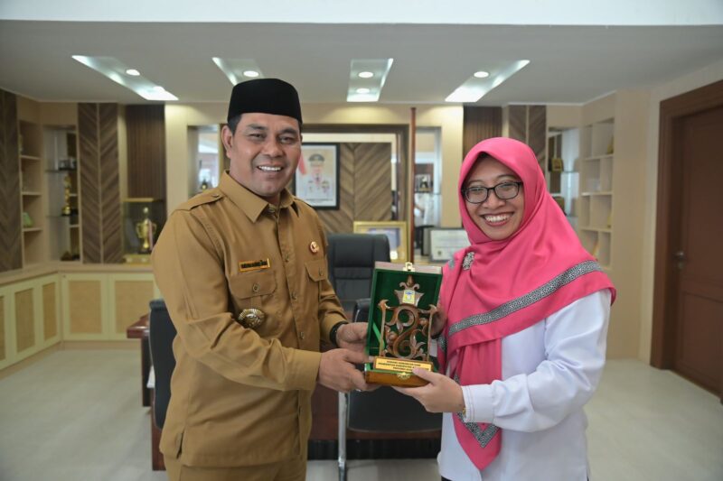 Bupati Aceh Besar, H. Muharram Idris menyerahkan plakat kepada Kepala KPP Pratama Aceh Besar, Suci Lestari Hakam, di ruang kerja Kantor Bupati Aceh Besar, Kota Jantho, Senin (10/3/2025). Foto: Dok. MC Aceh Besar