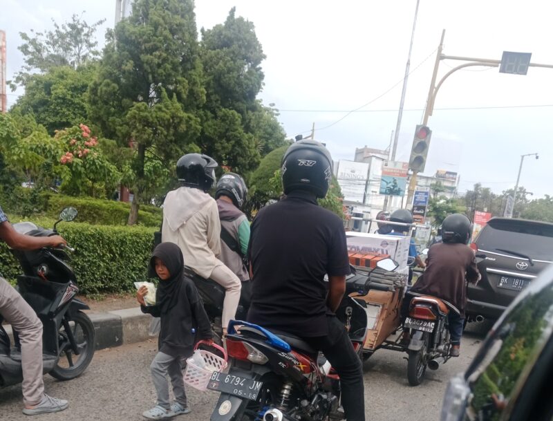 Foto anak kecil terlihat sedang berjualan di persimpangan lampu merah kawasan Simpang BPKP Lambhuk, Kota Banda Aceh. Foto: Dok. Pribadi/NOA