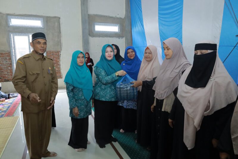 Ketua TP PKK Aceh Besar Hj Rita Mayasari menyerahkan bantuan kepada seorang masyarakat yang tergolong dalam keluarga rentan, pada pembukaan Sekolah Lansia Ranub Seulaseh, di Meunasah Gampong Meunasah Karieng, Kemukiman Lamlhom, Kecamatan Lhoknga, Kabupaten Aceh Besar, Senin (28/4/2025). Foto: Dok. MC Aceh Besar