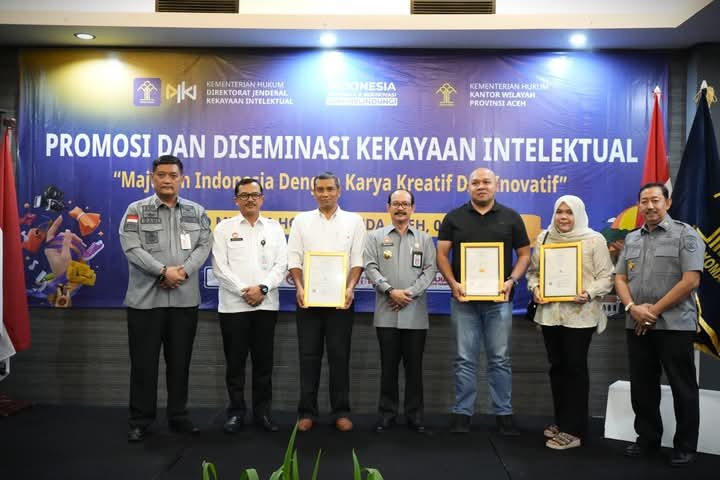 Kakanwil Kemenkum Aceh Meurah Budiman (Tengah) saat menyerahkan sertifikat merek kepada pelaku usaha di Hotel Kyriad Muraya, Banda Aceh, Selasa (6/5/2025). (Foto : NOA.co.id/HO-kanwil Kemenkum Aceh).