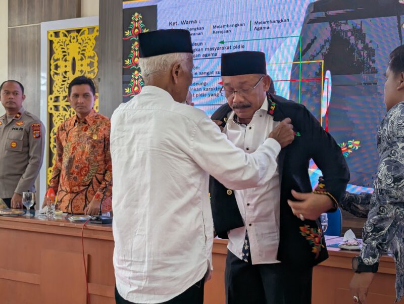 Pemangku adat saat memakai baju khas Pidie kepada Bupati Pidie, Sarjani Abdullah saat peluncuran di Oproom Sekdakab Pidie, Kamis (15/5/2025) (Foto.Amir Sagita.NOA.co.id)