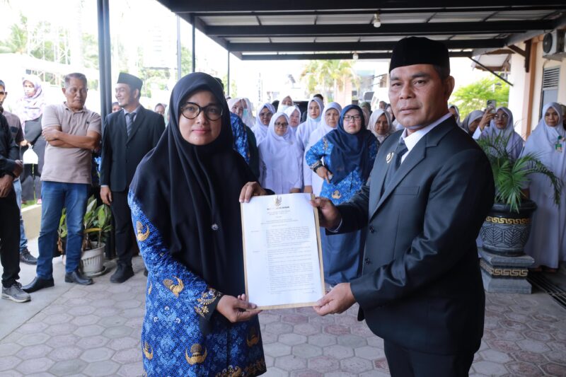 Bupati Aceh Besar Muharram Idris menyerahkan SK kepada Nelly Ulfiati SKM MPH sebagai Pelaksanaan Tugas (Plt) Kepala Dinas Kesehatan Kabupaten Aceh Besar usai melantik melantik dr. Bunaiya Putra MKM sebagai Direktur Rumah Sakit Umum Daerah (RSUD) Aceh Besar, di Teras RSUD setempat, Indrapuri, Senin (02/06/2025). Foto: Dok. Prokopim Aceh Besar
