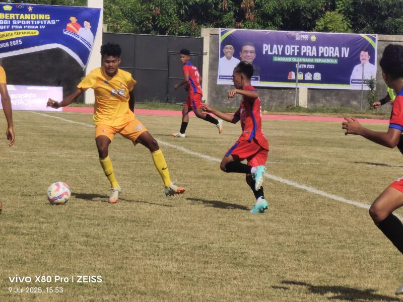 Pemain Nagan Raya memakai kustim warna kuning sedang menggiring bola dan dibayang bayangi pemain Aceh Barat pada laga Playoff Pra PORA Cabor Sepak Bola di Stadion Blang Paseh Kota Sigli, Rabu (9/7/2025) (Foto.Amir Sagita.NOA.co.id).