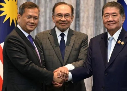 Perdana Menteri Malaysia Anwar Ibrahim (tengah), Perdana Menteri Kamboja Hun Manet (kiri), dan Pelaksana Tugas Perdana Menteri Thailand Phumtham Wechayachai berjabat tangan setelah perundingan mengenai kemungkinan gencatan senjata antara Thailand dan Kamboja di Putrajaya pada 28 Juli 2025. Foto: AFP